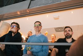 Mitarbeiter und Teilnehmende schauen gemeinschaftlich das Spiel der Kölner Haie