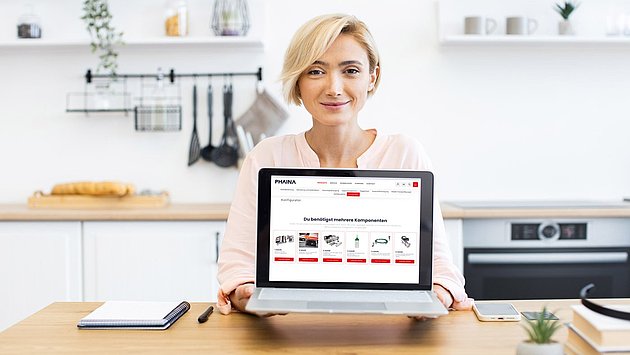 Eine Frau hält einen Laptop ins Bild mit der Guided Selling Lösung von PHAINA