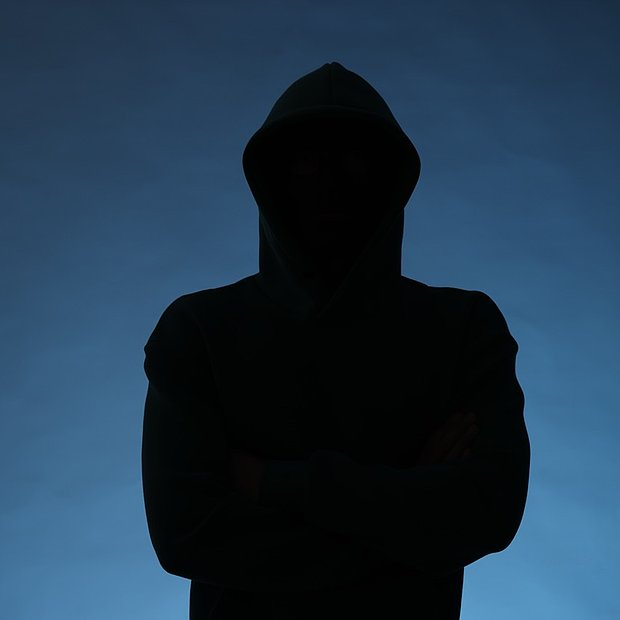Silhouette eines anonymen Mannes mit Kapuze auf blauem Hintergrund