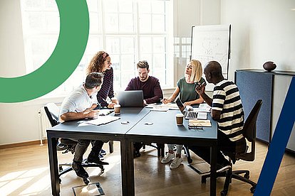 Ein Team in einer Werbeagentur arbeitet zusammen an einem neuen Hosting-Konzept