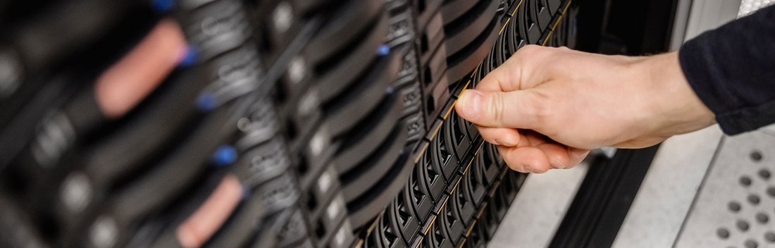 Mitarbeitender im Service betätigt ein Auswurf einer Festplatte an einem Storage-System